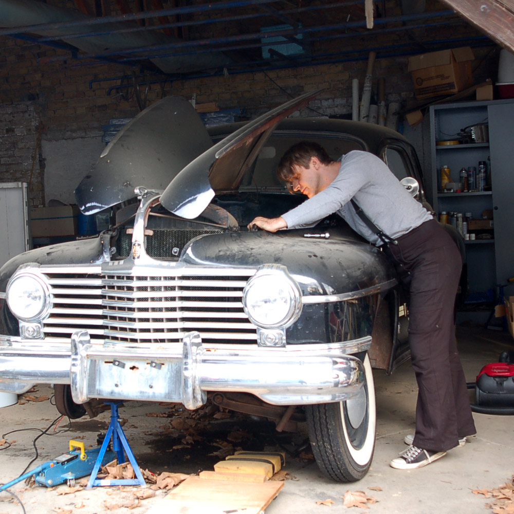 Am Vecona Vintage Mobil, unserem Dodge von 1942 gibt es immer etwas zu schrauben. Kai trägt dafür die Workerhose Rusty Dusty aus schwarzem, stabilen Canvas von Vecona Vintage.