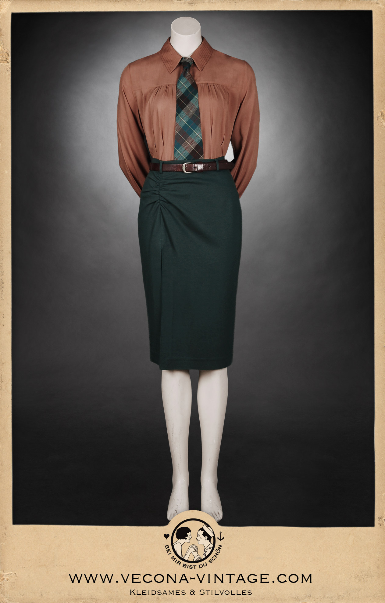 Front view of the 1940s high waist pencil skirt Apache in dark green with the long sleeve blouse Greta in rust red styled with a checkered vintage tie and a brown leather belt.
