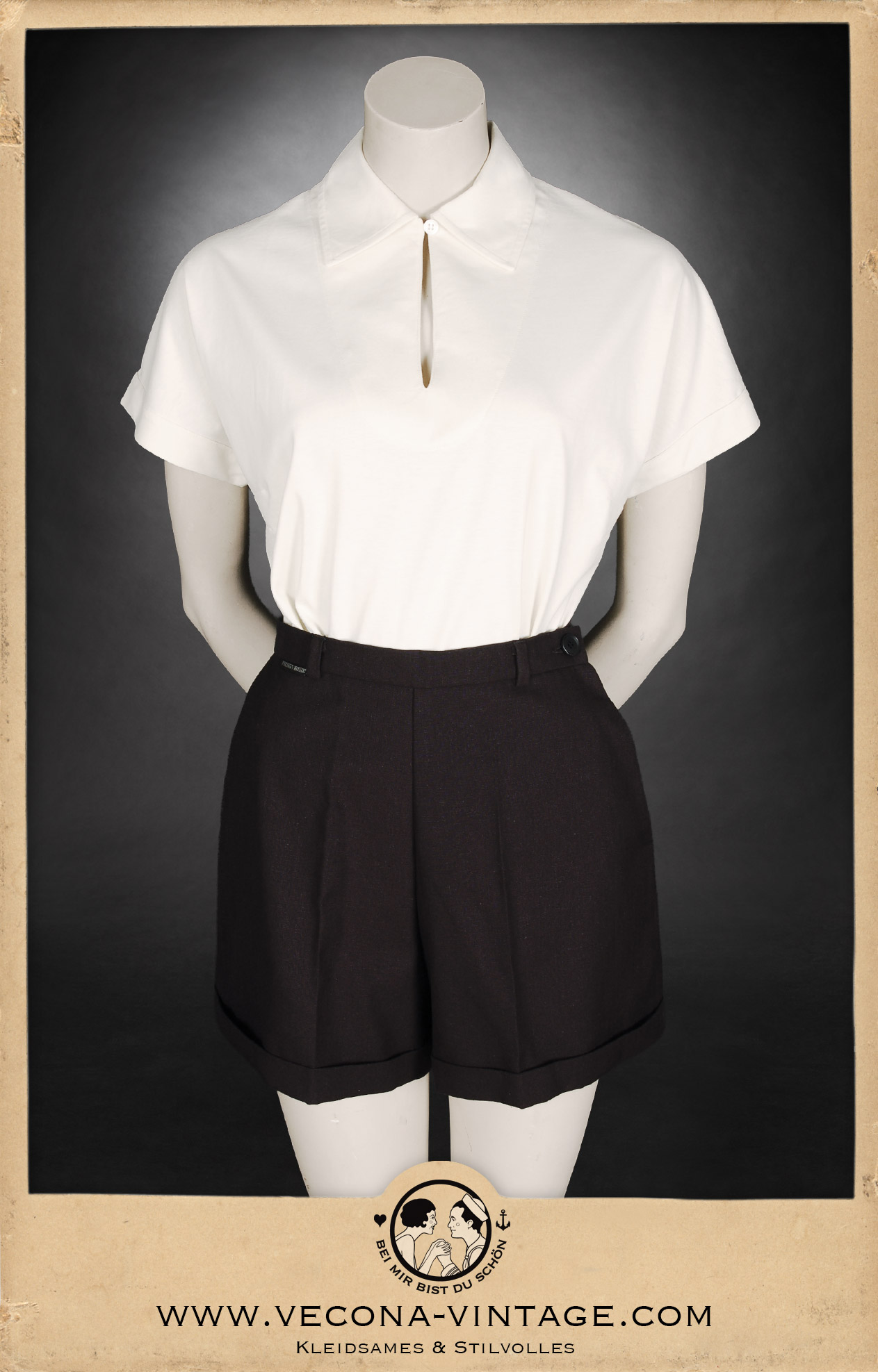 1930s vintage women's outfit consisting high waisted shorts in black and a cream white polo shirt, great for summer vacation and vintage sports. Front view.