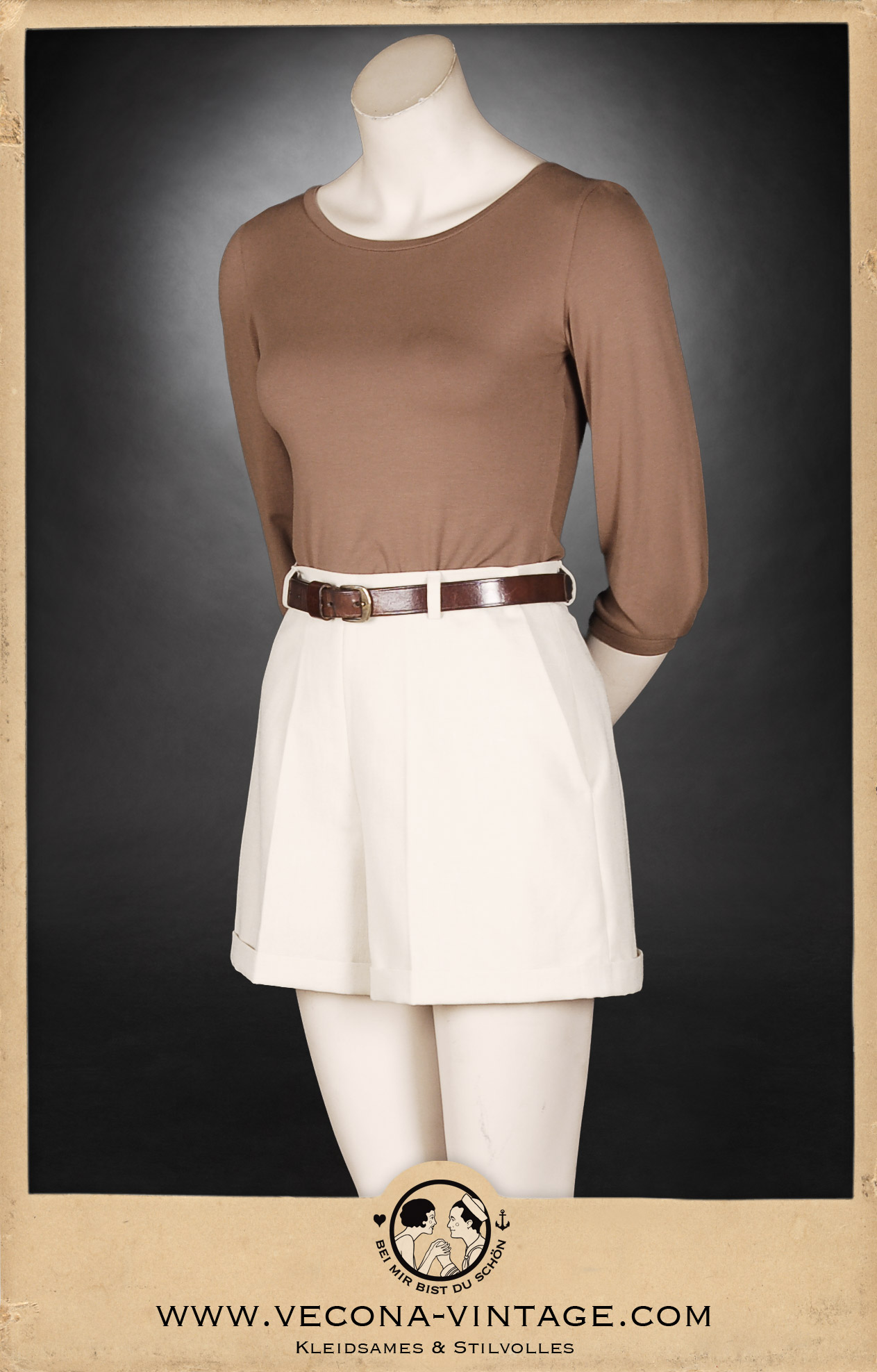 ommerliches Vintage-Damenoutfit bestehend aus hellen Ecru-Leinenshorts mit hohem Bund und weitem Bein, kombiniert mit einem schlichten braunen Jersey-Shirt mit Dreiviertelarm und Ledergürtel. Ansicht der Vorderseite.