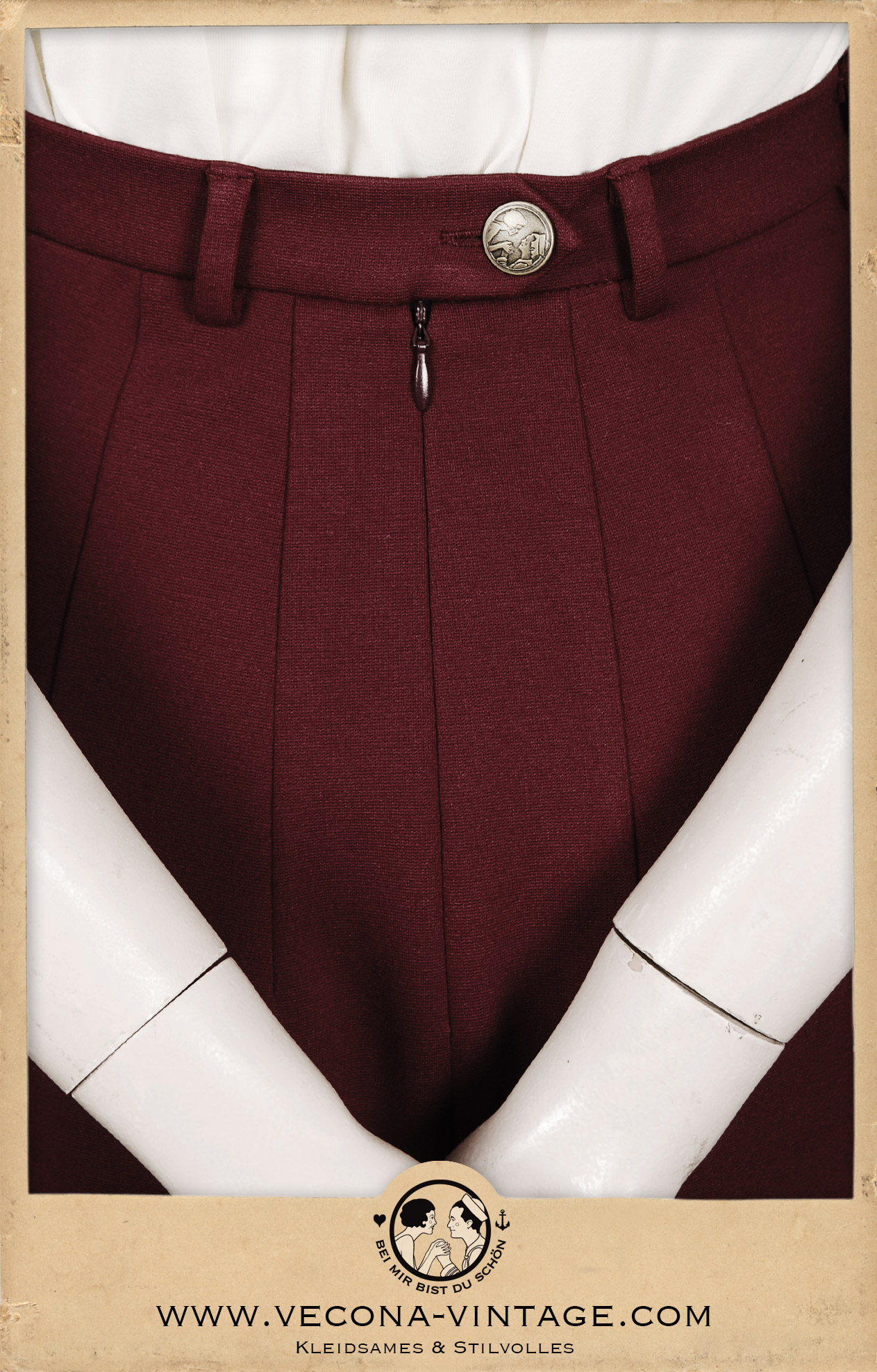 Detail of the invisible zipper at the center back and the Vecona Vintage brass logo button at the 1940s high waist pencil skirt Apache in dark red.